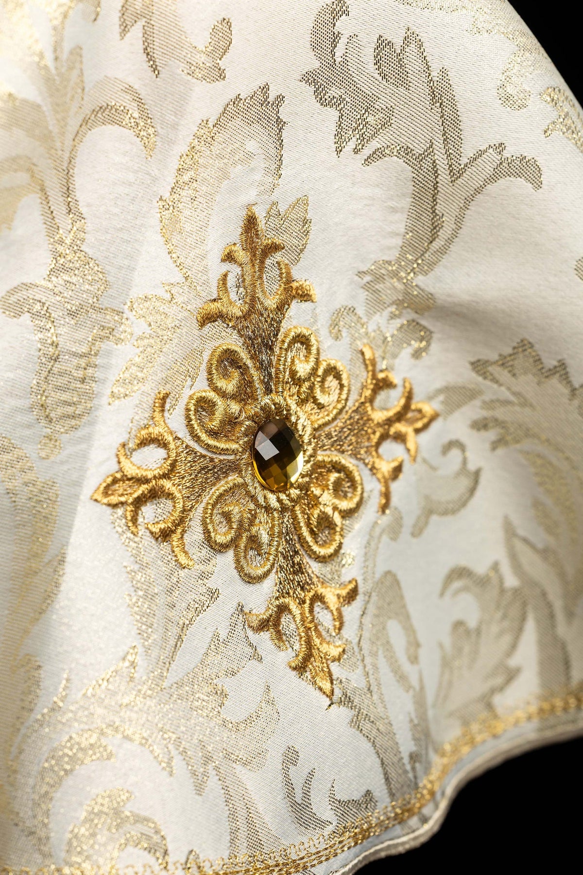 Close-up of the ciborium veil with embroidered gold cross motif and decorative stone