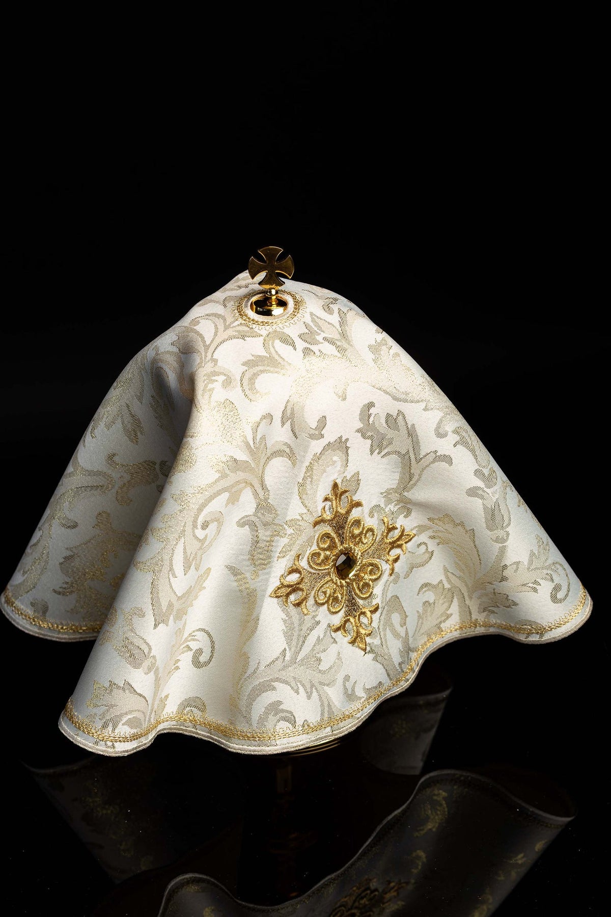Angled view of the ciborium veil showing ecru damask fabric and gold trim