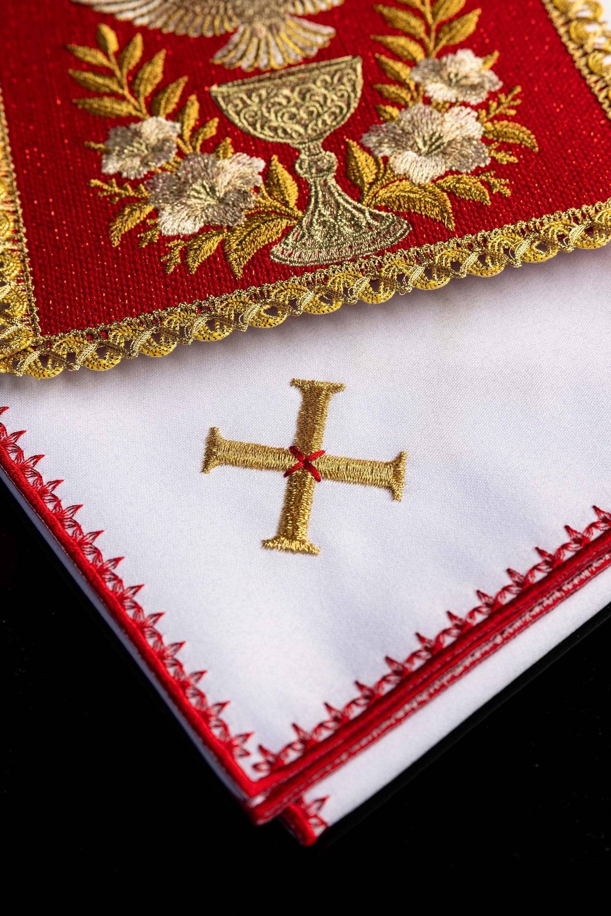 Close-up of the altar linen set showing a gold embroidered cross and red edging