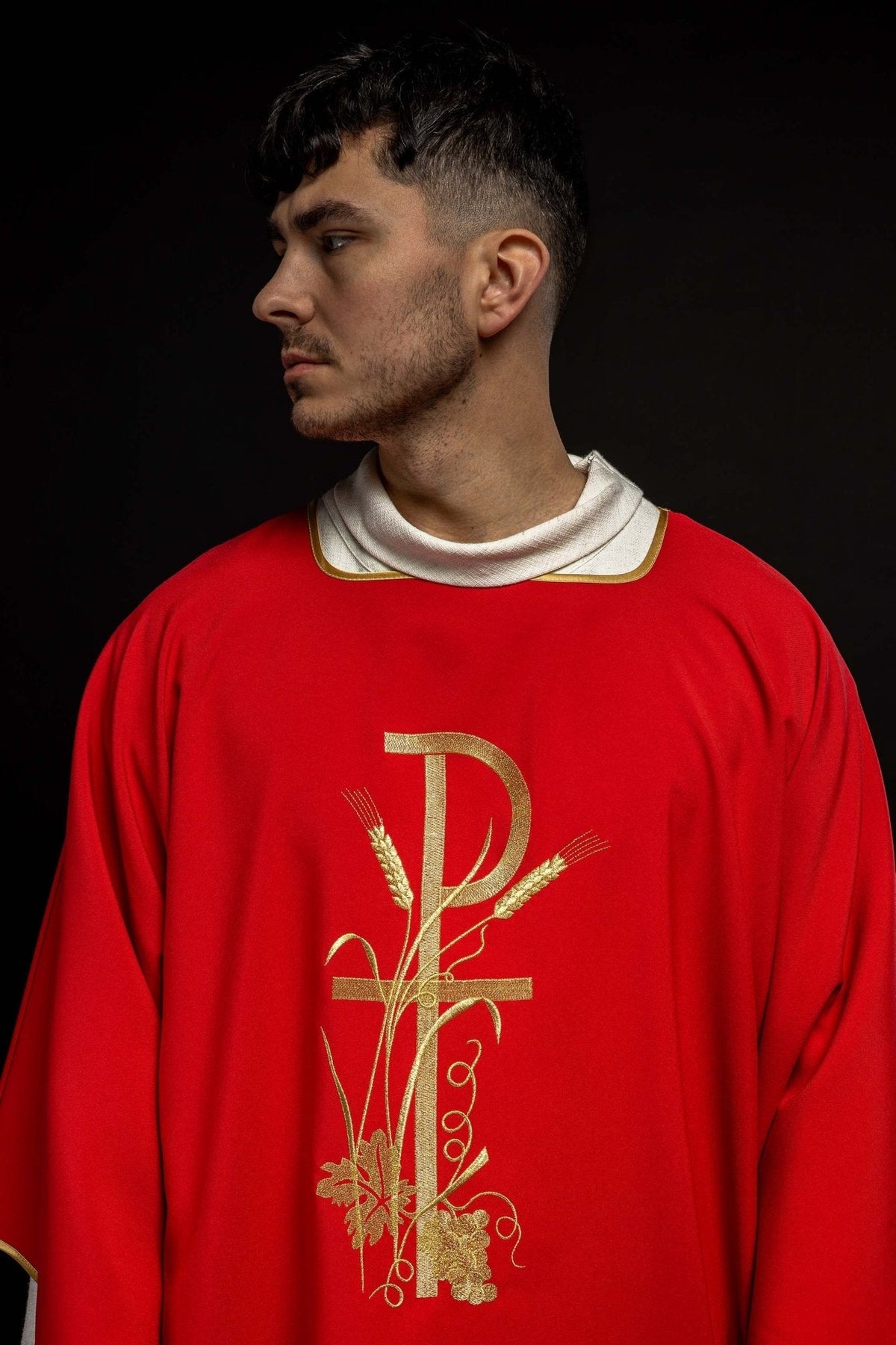 Red dalmatic with golden embroidery of the Pax cross