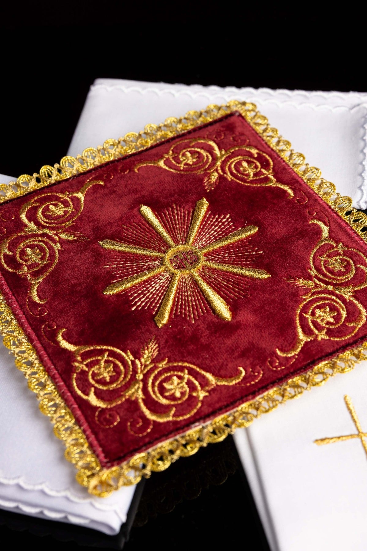 Close-up of the chalice linens set showing ornate gold embroidery and scalloped white linen edges
