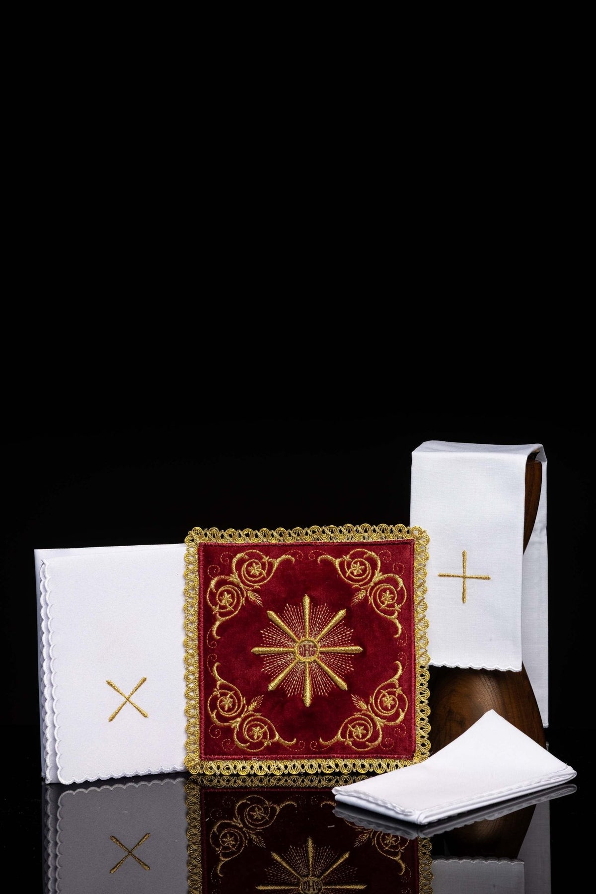 Front view of a Red velvet embroidered chalice linens set with gold embroidery and scalloped white linens