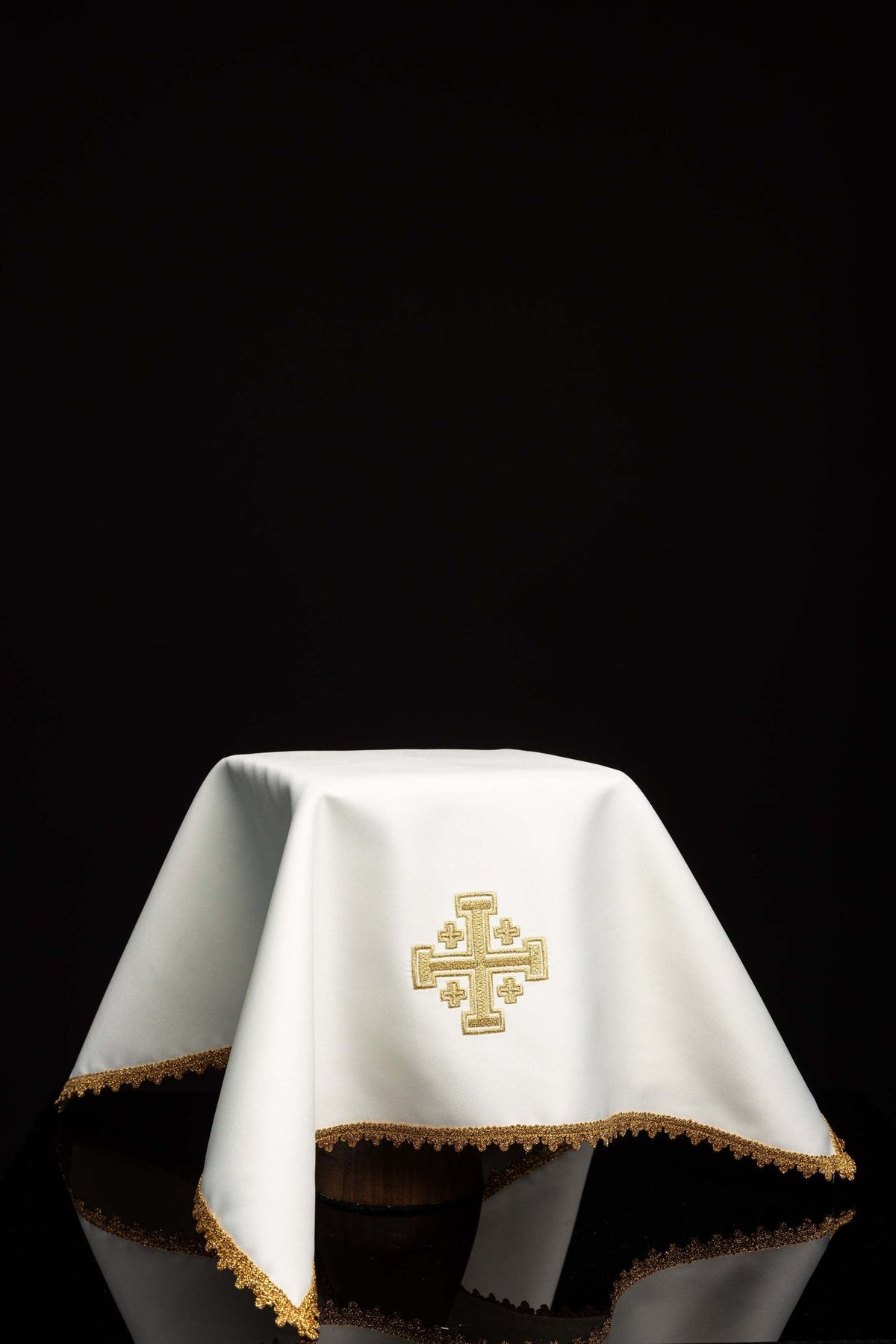 Worn view of a white chalice veil with Jerusalem Cross embroidery and gold trim